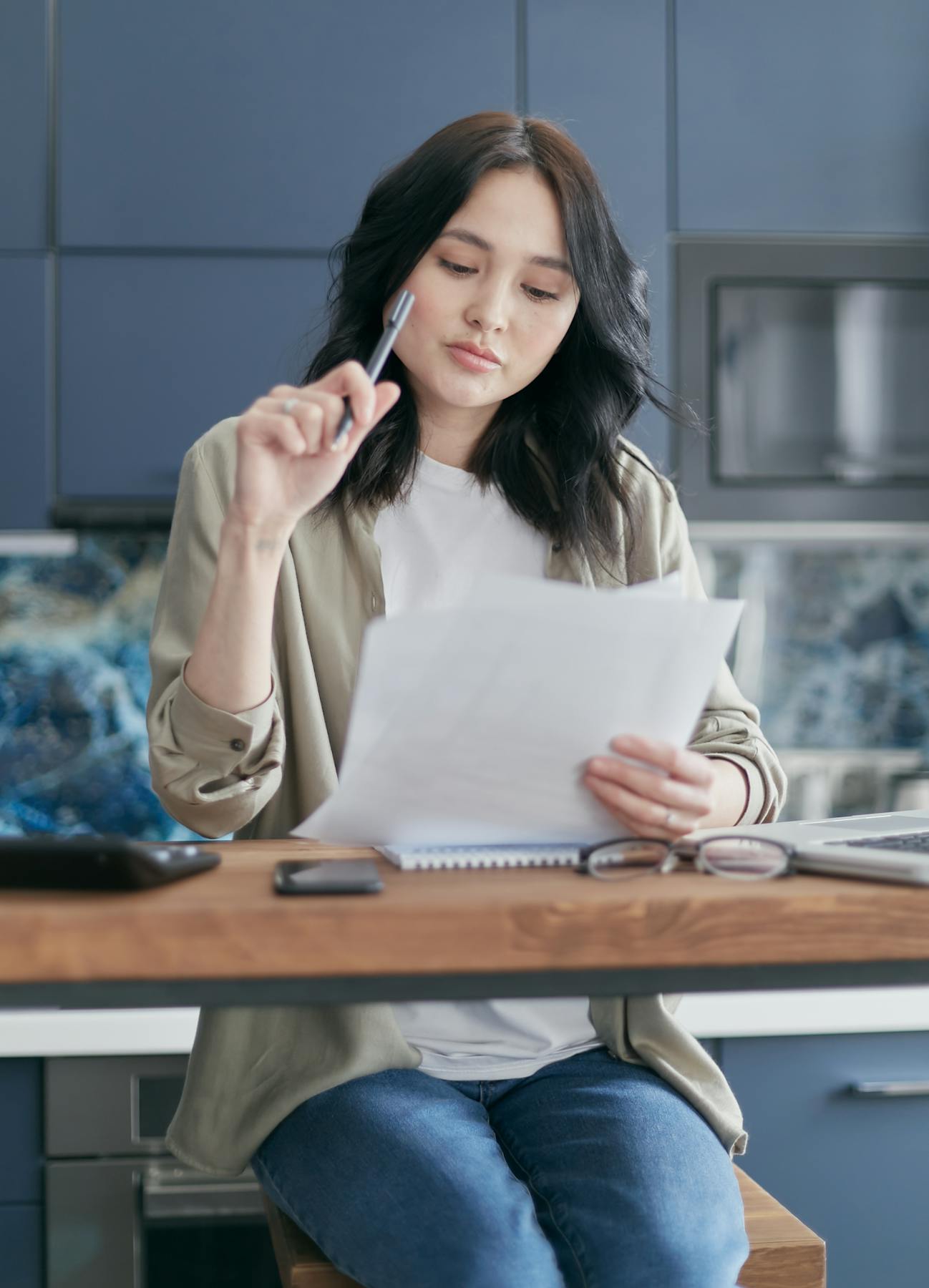 A homeowner reviewing assessment paperwork at a kitchen table